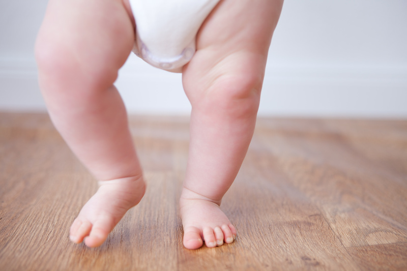 Developmental Milestones for Baby’s First Year; close up of baby feet doing the first steps