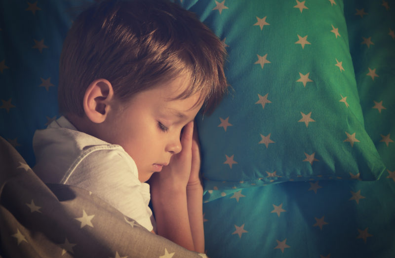 kids and sleep; Adorable little boy sleeping in bed