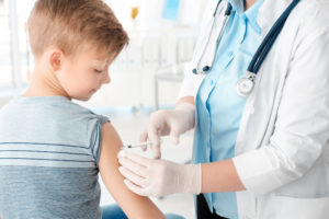 Doctor vaccinating little boy in hospital; Blog: Are Vaccines safe for children?