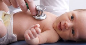 Close-up, high-key photo of a newborn baby getting examined by a doctor; blog: What is Newborn Screening?