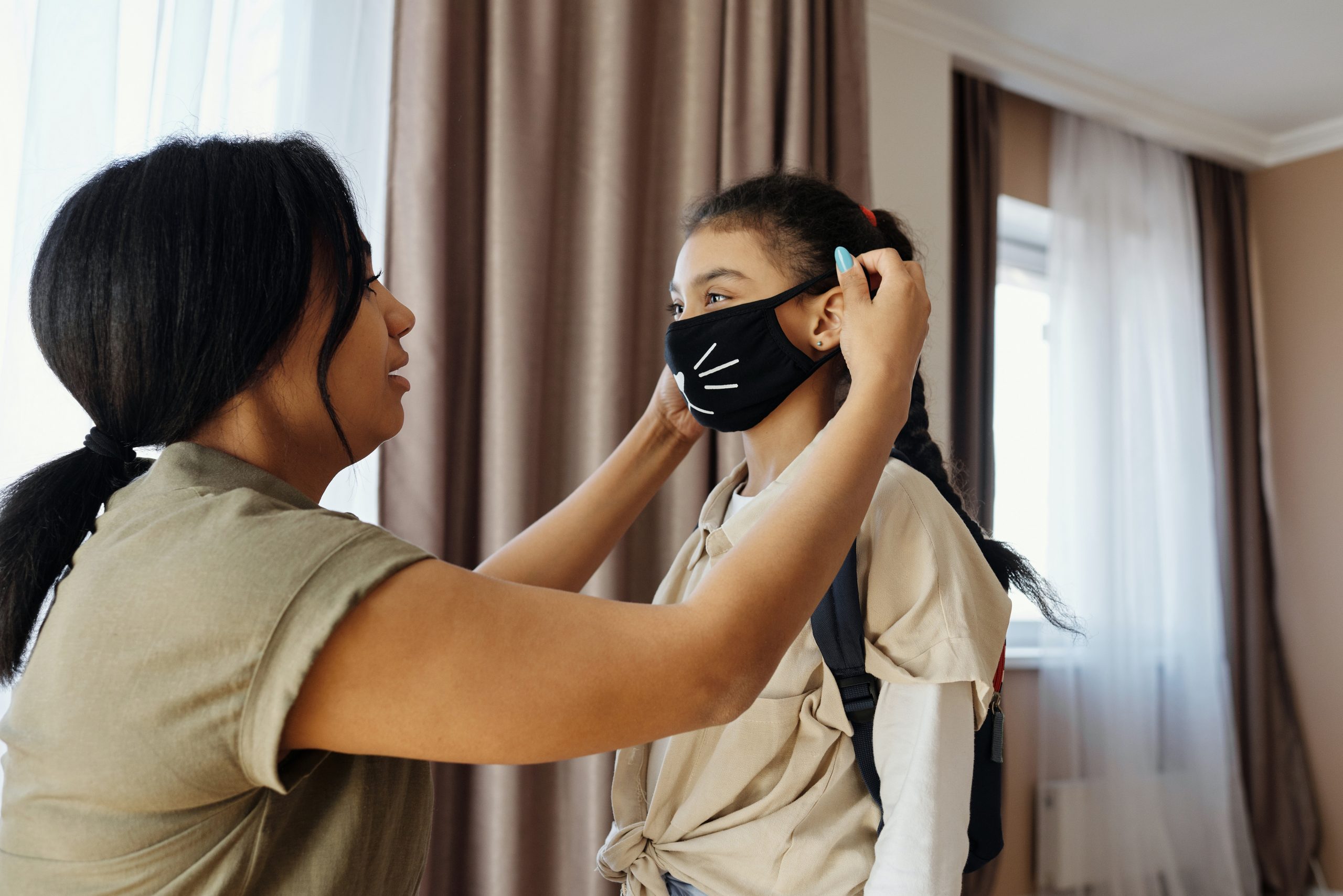 mom putting face mask on child