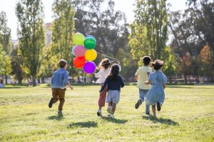 children running with balloons