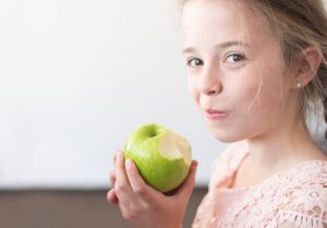 little girl eating apple national health month