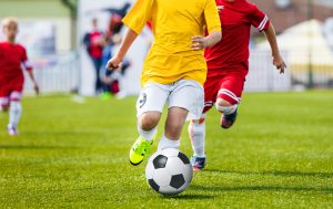 Running Youth Soccer Football Players. Boys Kicking Soccer Match. Children Football Players Running After the Ball. Kids Sport Duel