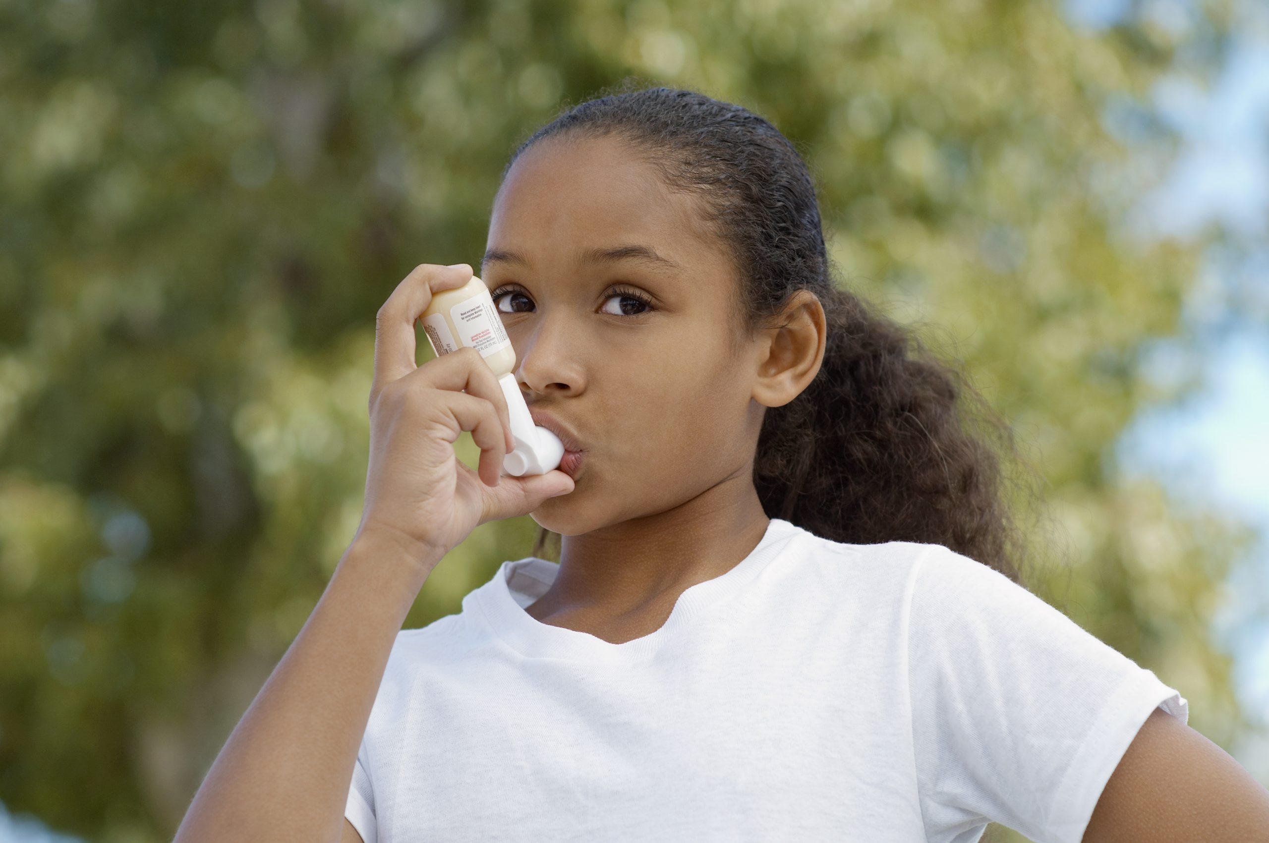 Closeup of a girl using asthma inhaler