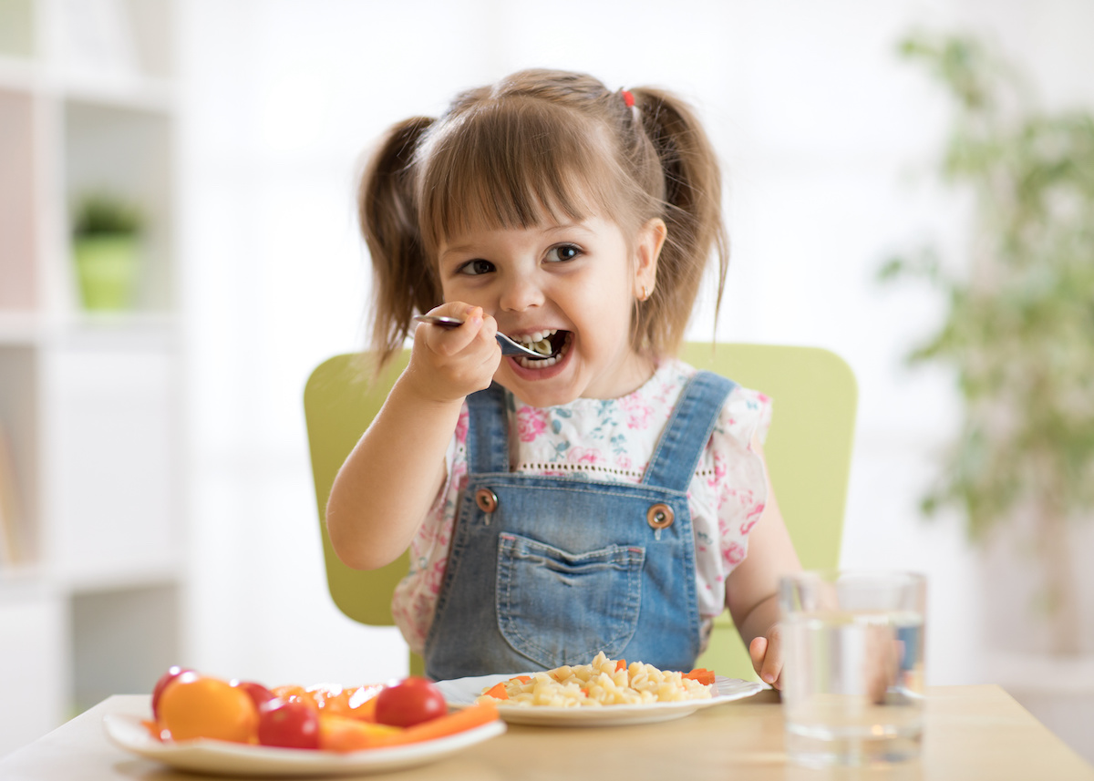 kid girl eating healthy food at home / blog - introducing solid foods